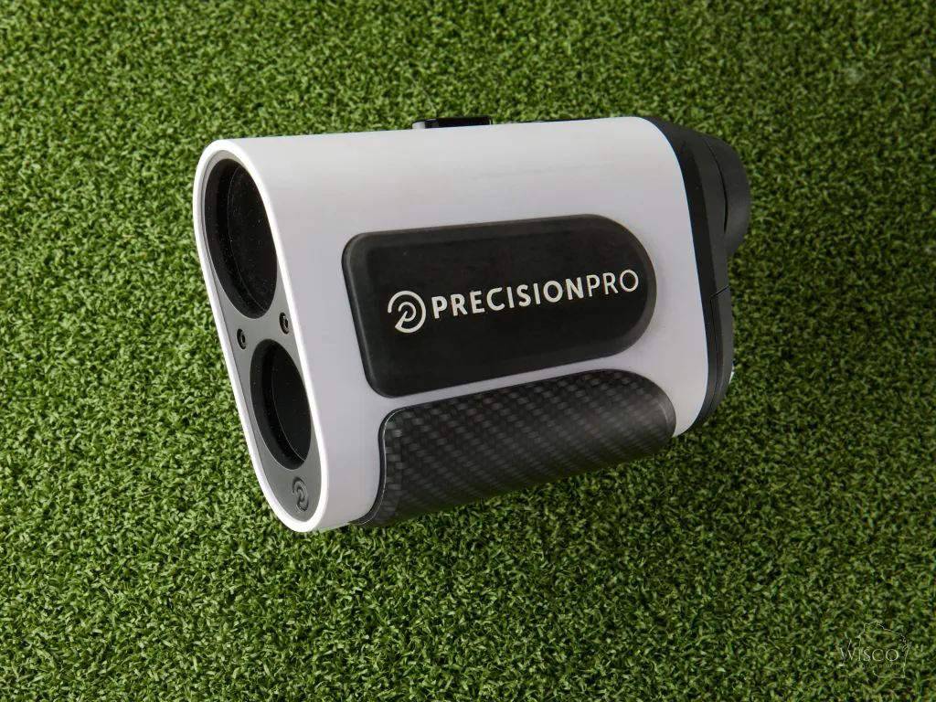 A closeup of the Precision Pro NX10 Slope Rangefinder sitting on lush green grass.