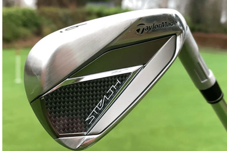 Close-up of a TaylorMade Stealth 6 iron against a blurred golf course background.