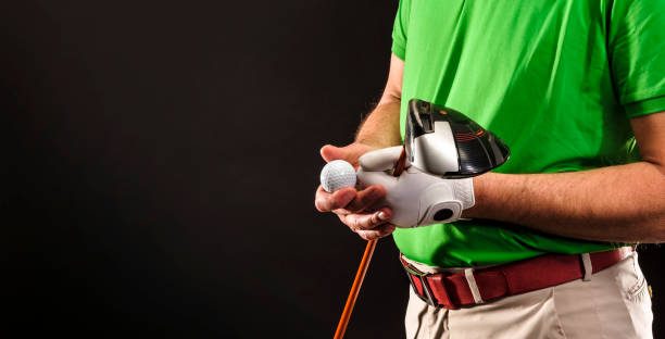 Close-up of a golfer with golf club, golf ball and glove before pulling