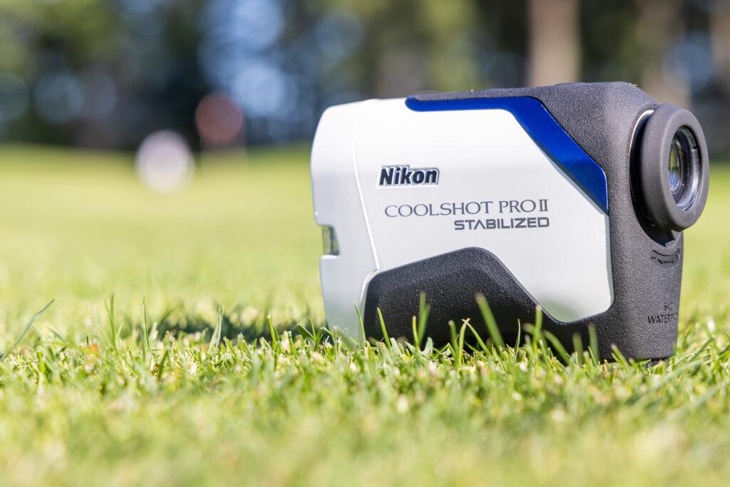 Close-up of a Nikon Coolshot Pro II Stabilized Rangefinder sitting on lush green grass.